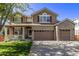 Two-story home with brick and siding, two-car garage, and landscaping at 11533 Dahlia St, Thornton, CO 80233