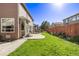 Spacious backyard with patio, grass, and a wooden fence at 11533 Dahlia St, Thornton, CO 80233