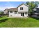 Back exterior view of a house with a large grassy yard at 19058 E Bonney Ct, Parker, CO 80134