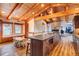 Open kitchen with island, breakfast nook, and wood beams at 537 Moonstone Rd, Breckenridge, CO 80424