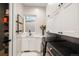 Bright laundry room with white cabinets, a utility sink, and modern appliances at 11229 Running Kit Pl, Franktown, CO 80116