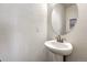 Small bathroom with pedestal sink and oval mirror at 224 S Old Hammer St, Aurora, CO 80018