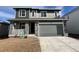 Two-story home with gray siding, stone accents, and a two-car garage at 270 Lark Sparrow Way, Bennett, CO 80102