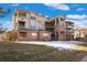 Exterior view of a multi-story brick apartment building with snow on the ground at 12762 Ironstone Way # 302, Parker, CO 80134