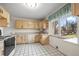 Kitchen with light wood cabinets, tile floor, and window at 3661 W Greenwood Pl, Denver, CO 80236