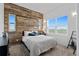 Bedroom with rustic wood accent wall and window at 6001 S County Road 161, Strasburg, CO 80136