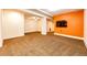 Finished basement area with an accent wall and large TV at 6751 S County Road 129, Bennett, CO 80102