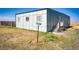Mobile home exterior showcasing a covered porch and a spacious yard at 6751 S County Road 129, Bennett, CO 80102