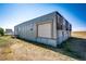 Mobile home's side view highlighting an attached garage and outdoor space at 6751 S County Road 129, Bennett, CO 80102