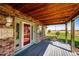 Inviting covered porch with red door and view of the surrounding landscape at 6751 S County Road 129, Bennett, CO 80102