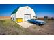 Detached garage with a large overhead door and a classic car at 6751 S County Road 129, Bennett, CO 80102