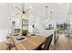 Open concept dining area with a spacious wooden table and modern lighting at 2164 Applewood Dr, Lakewood, CO 80215