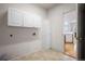 Laundry room with white cabinets, tile flooring, and storage closet at 10730 Eliot Cir # 103, Denver, CO 80234