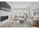 Spacious living room with large windows, light-colored sofas and a fireplace at 17428 Hop Clover Ave, Parker, CO 80134