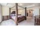 Main bedroom with large four-poster bed and access to bathroom at 20052 W 95Th Pl, Arvada, CO 80007