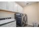 Laundry room with white cabinets, large capacity washer and dryer at 20052 W 95Th Pl, Arvada, CO 80007