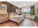 Spacious bedroom with hardwood floors, large windows, and an accent wall at 1210 Wildcat Bend Ct, Castle Rock, CO 80108