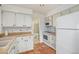 Galley kitchen with white cabinets, tile floors, and a small dining area at 13824 E Lehigh Ave # C, Aurora, CO 80014