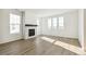 Living room with hardwood floors, fireplace and large windows at 2186 Farmlore Dr, Brighton, CO 80601