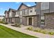 Row of townhomes, showcasing landscaping and walkway at 19733 W 93Rd Ln # D, Arvada, CO 80007
