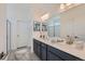 Double vanity bathroom with dark cabinets and a large mirror at 3025 Nectar Street St, Strasburg, CO 80136