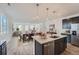 Modern kitchen with dark cabinets, granite island, and stainless steel appliances at 3025 Nectar Street St, Strasburg, CO 80136