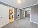 Bedroom with grey carpet, mirrored closet doors, and view of kitchen and bathroom at 1 S Pennsylvania St # 102, Denver, CO 80209