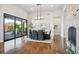 Bright dining room with hardwood floors, sliding glass doors, and a large light fixture at 7912 Galileo Way, Littleton, CO 80125