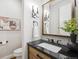 Modern powder room with a sleek vanity, dark countertop, and stylish mirror at 7912 Galileo Way, Littleton, CO 80125