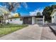 Ranch style home with carport, mature landscaping, and paved driveway at 1420 S Ivy Way, Denver, CO 80224