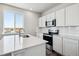 Modern kitchen with white cabinets and stainless steel appliances at 3302 N Highlands Creek Pkwy, Aurora, CO 80019