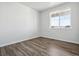 Simple bedroom with large window and hardwood floors at 3302 N Highlands Creek Pkwy, Aurora, CO 80019