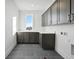 Modern laundry room with dark cabinetry, quartz countertops, and tile flooring at 2650 Zenobia, Denver, CO 80212
