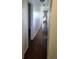 Long hallway with dark brown flooring and access to rooms at 3228 W Virginia Ave, Denver, CO 80219