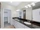 Double vanity bathroom with granite countertops and a large mirror at 5535 Danube St, Denver, CO 80249