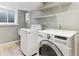 Basement laundry room with washer, dryer and shelving at 11615 Masonville Dr, Parker, CO 80134
