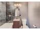 Modern bathroom with dark marble tile, gold fixtures, and a new vanity at 13194 W 23Rd Ave, Golden, CO 80401