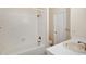 Bright bathroom with white tile, bathtub, and single vanity sink at 1915 S Balsam St, Lakewood, CO 80227