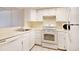 Kitchen equipped with essential appliances, white cabinetry, and ample counter space at 1915 S Balsam St, Lakewood, CO 80227