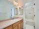 Bathroom with wood cabinets, double vanity, and shower/tub combo at 8142 E Vassar Dr, Denver, CO 80231