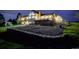 Night view of a two-story house with deck, landscaping, and detached shed at 11251 Forest Hills Dr, Parker, CO 80138