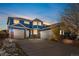 Two-story house with a blue exterior, brick accents, and a three-car garage at 12956 E 107Th Pl, Commerce City, CO 80022