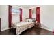 Bedroom with red curtains, wood flooring, and a double bed at 7630 Pecos St, Denver, CO 80221