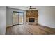 Living room features a stone fireplace and sliding glass door to patio at 7870 W 87Th Dr # J, Arvada, CO 80005