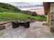 Relaxing stone patio with fire pit, seating, and hot tub, offering scenic views at 12963 Silver Elk Ln, Littleton, CO 80127