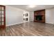 Living area with hardwood floors, brick fireplace and access to kitchen at 7814 Village Rd, Parker, CO 80134