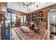 Library with built-in bookshelves, leather chairs, and hardwood floors at 7944 Dante Dr, Littleton, CO 80125