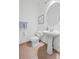 Clean bathroom with pedestal sink, toilet and round mirror at 2855 Rock Creek Cir # 191, Superior, CO 80027