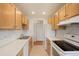 Kitchen with light wood cabinets, tiled backsplash, and stainless steel sink at 17473 E Mansfield Ave # 111Wl, Aurora, CO 80013