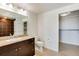 Bathroom with granite vanity, large mirror, and walk-in closet at 2001 Lincoln St # 1024, Denver, CO 80202